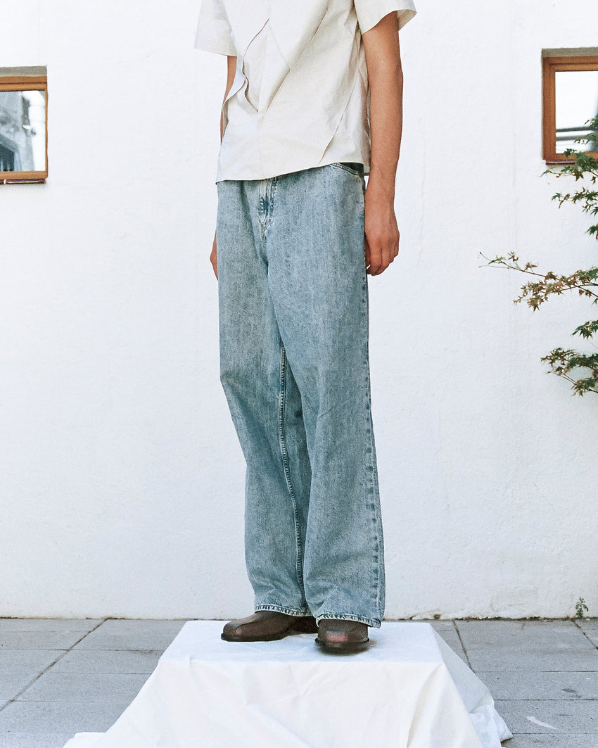 Lifestyle full-body photo of a person wearing Pedal Loafer Oil Nappa Mud shoes with light-wash wide-leg denim jeans
