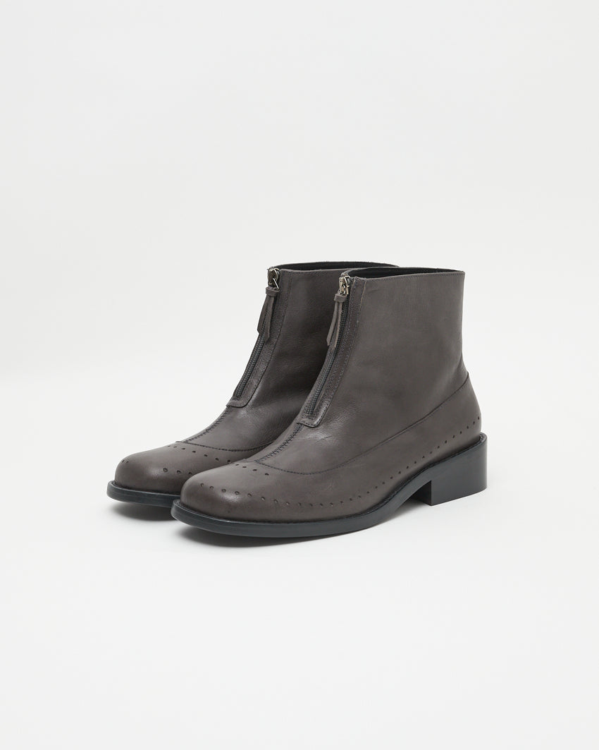 Pair of Cove Boot Jeongli Grey boots, close angled front view showing front zips and brogue perforated toe caps