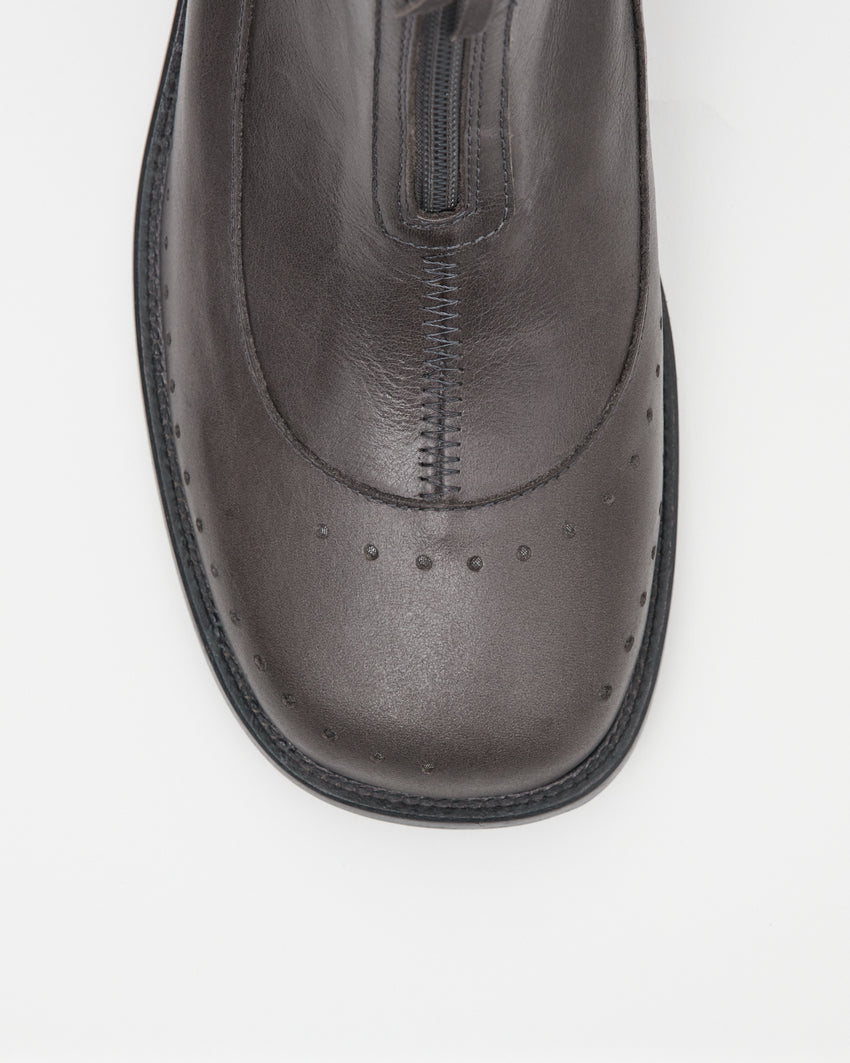 Close-up top-down view of the Cove Boot Jeongli Grey toe box showing the front zip pull and brogue perforated detailing