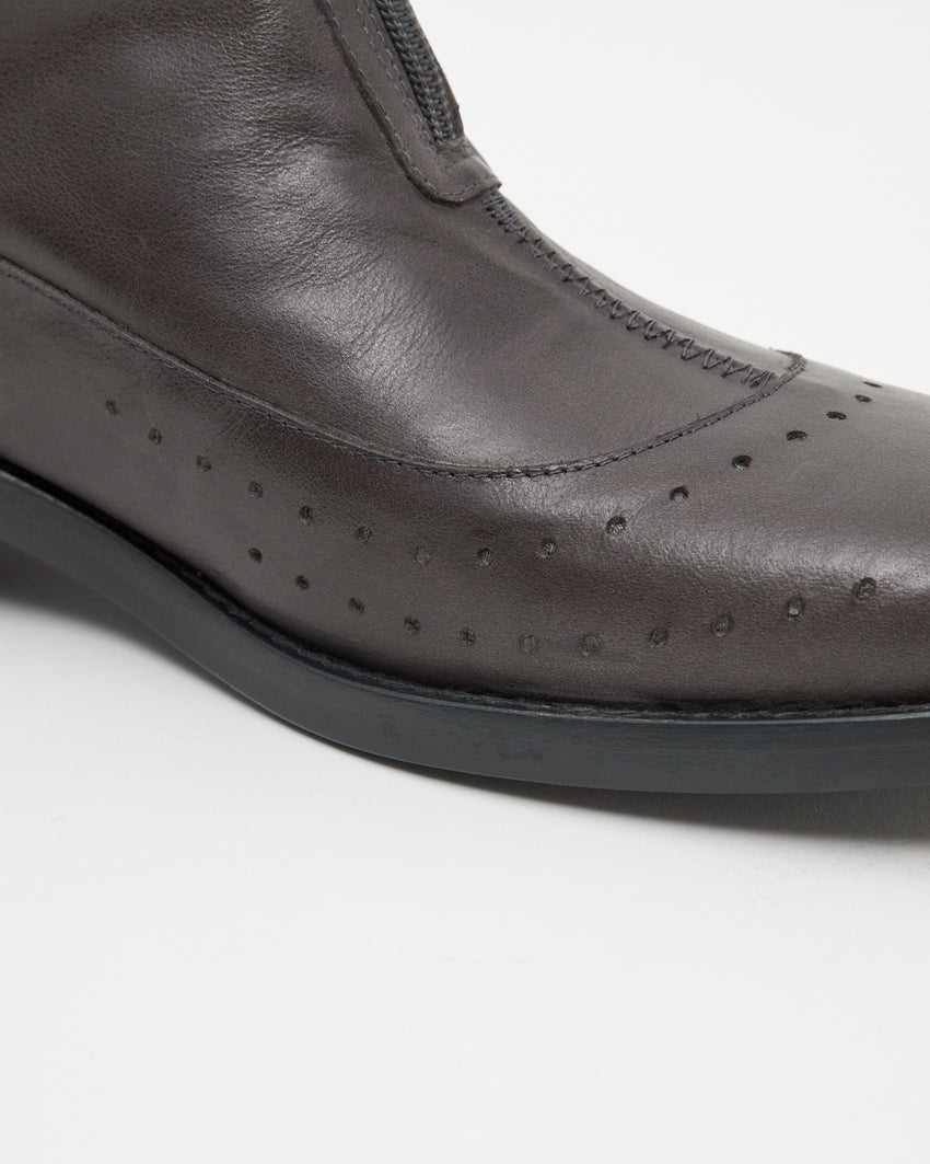 Close-up angled front view of the Cove Boot Jeongli Grey toe seam showing brogue perforation and zip