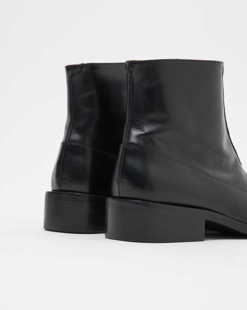 Back view of a pair of Cove Boots in pull-up leather black, showing the block heels