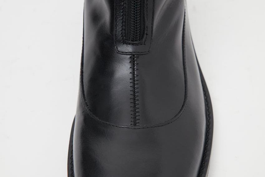 Close-up of the Cove Boot's front seam and zip in pull-up leather black