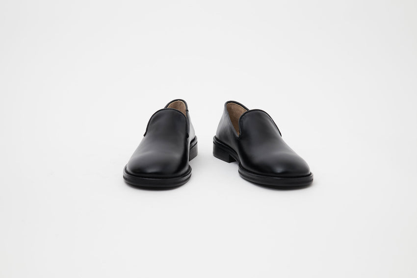 Front-angled view of Legacy Slipper pair in black calfskin leather.