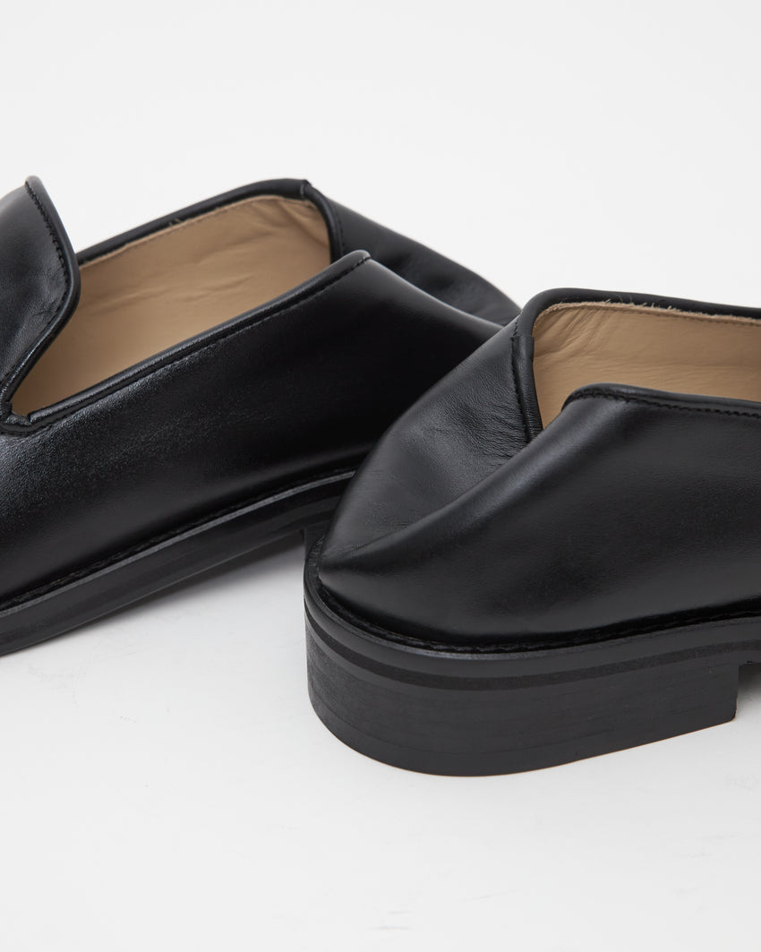 Close-up view of two collapsable heels of Legacy Loafer in black calfskin leather by Paracia.