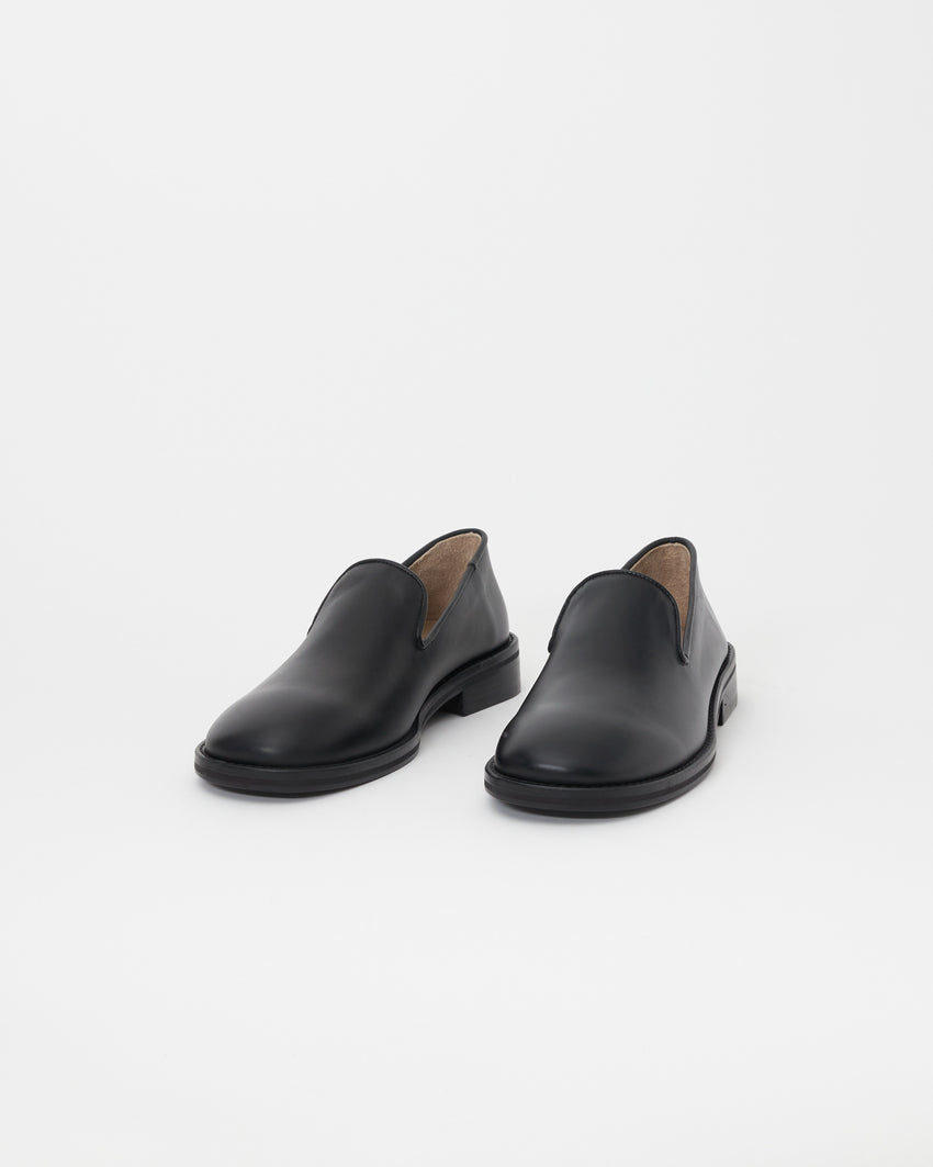 Front three-quarter view of Legacy Slipper pair in black calfskin leather.