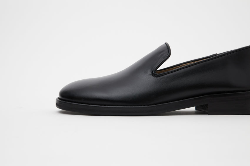 Close-up side profile of Legacy Slipper toe and vamp in black calfskin leather.