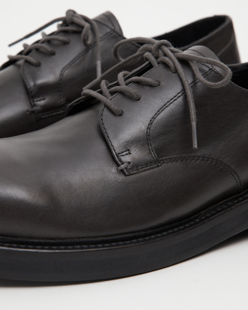 Close up view of stitching and laces on Mid-Heel Derby in dark grey oil nappa leather.