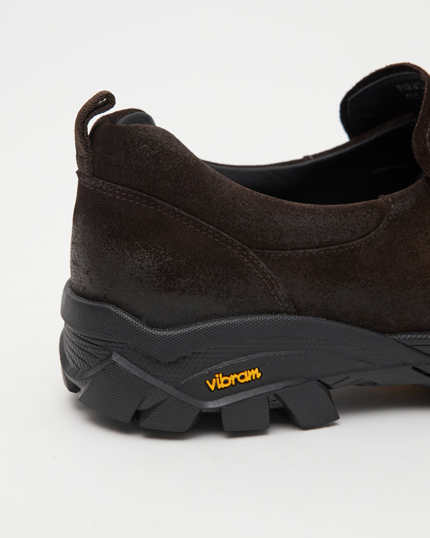 Close-up side view of a single Non-Safety Slip-on Waxed Suede Deep Brown shoe showing black interior collar and Vibram sole tag