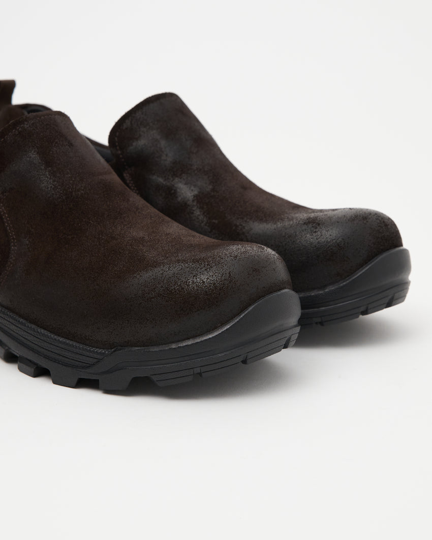Close-up angled front view of a pair of Non-Safety Slip-on Waxed Suede Deep Brown shoes showing black interior collar and lugged sole