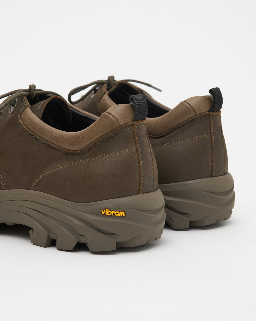 Close-up angled front view of a pair of Non-Safety Shoe Nubuck Brown Stone shoes showing laces, black interior collar, and Vibram sole tag