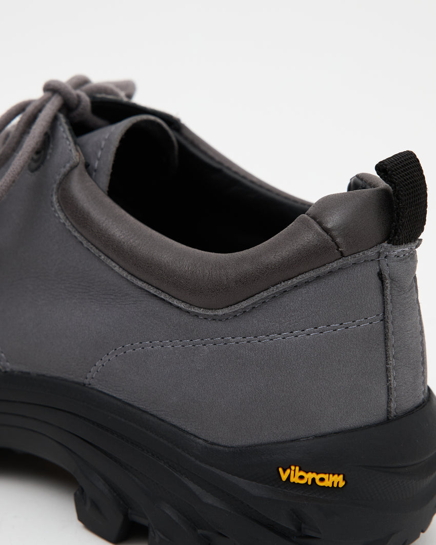 Close-up side view of a single Non-Safety Shoe Nubuck Ink Blue shoe showing black interior collar and Vibram sole tag