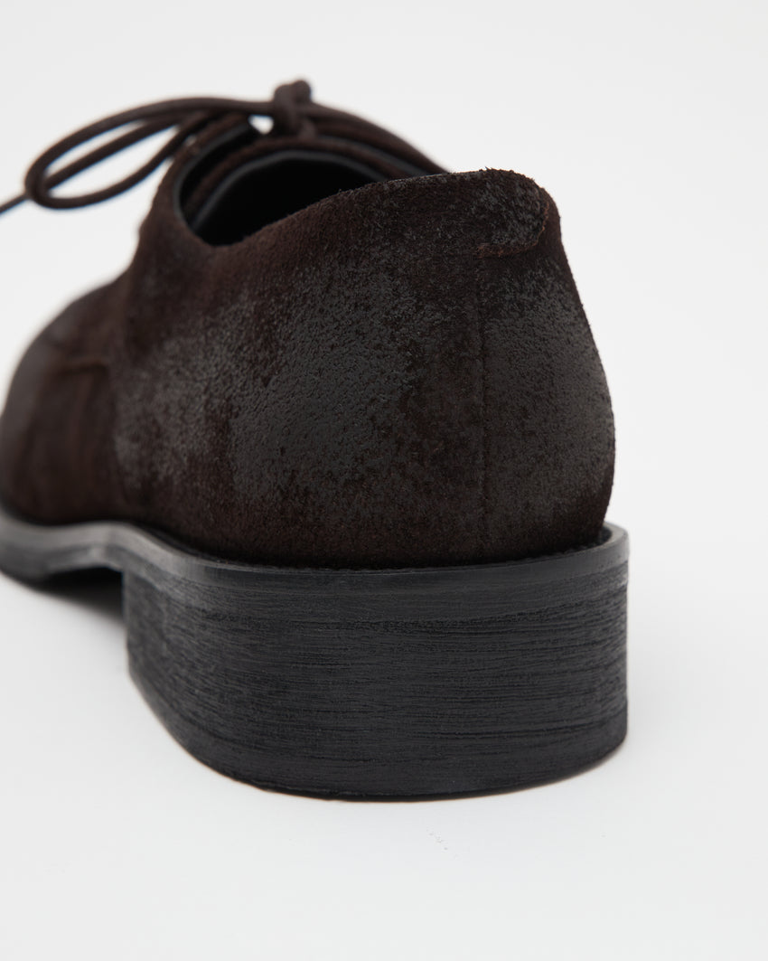 Close-up back-side view of a single Old Buster Waxed Suede Deep Brown shoe showing heel and suede texture