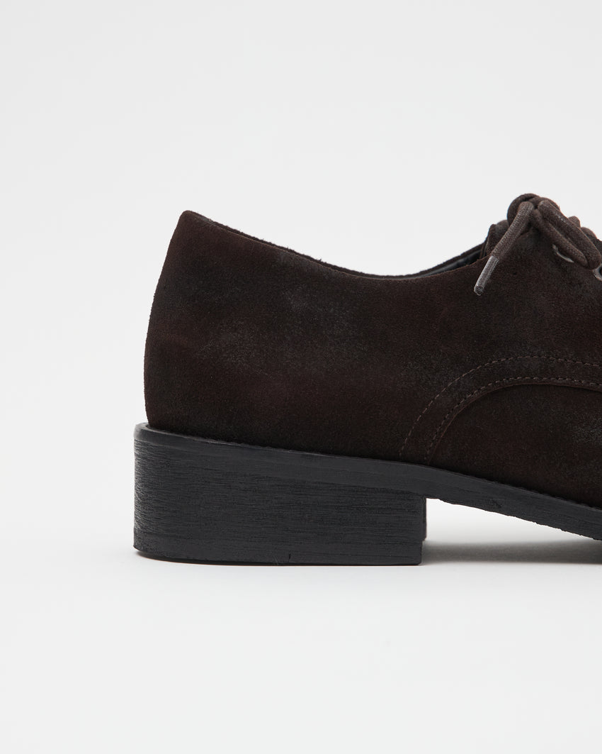 Close-up side profile view of a single Old Buster Waxed Suede Deep Brown shoe showing the heel
